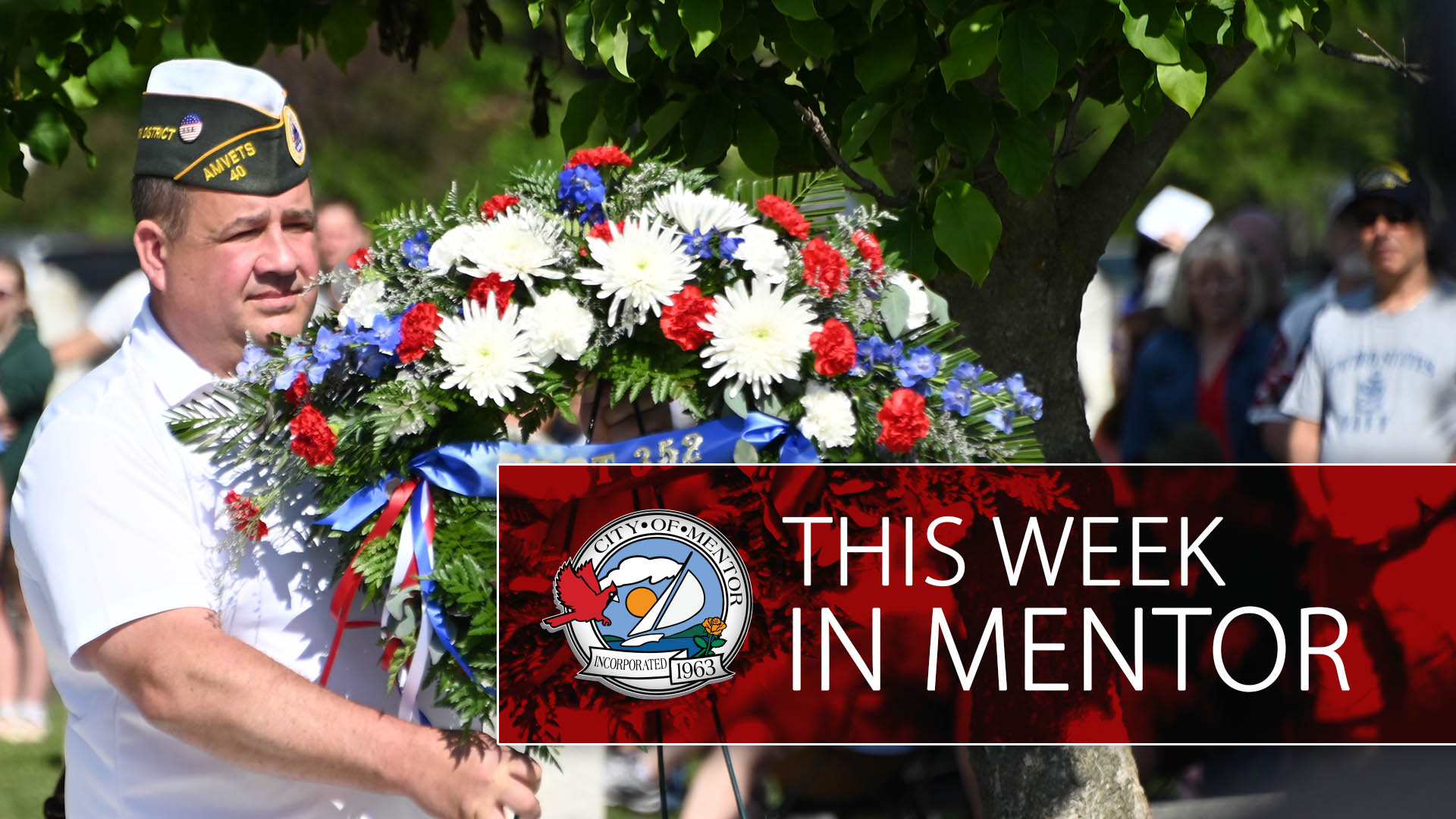 An image of a person carrying a wreath at the Mentor Memorial Day Ceremony with the words "This Week in Mentor" overlayed on a maroon field.